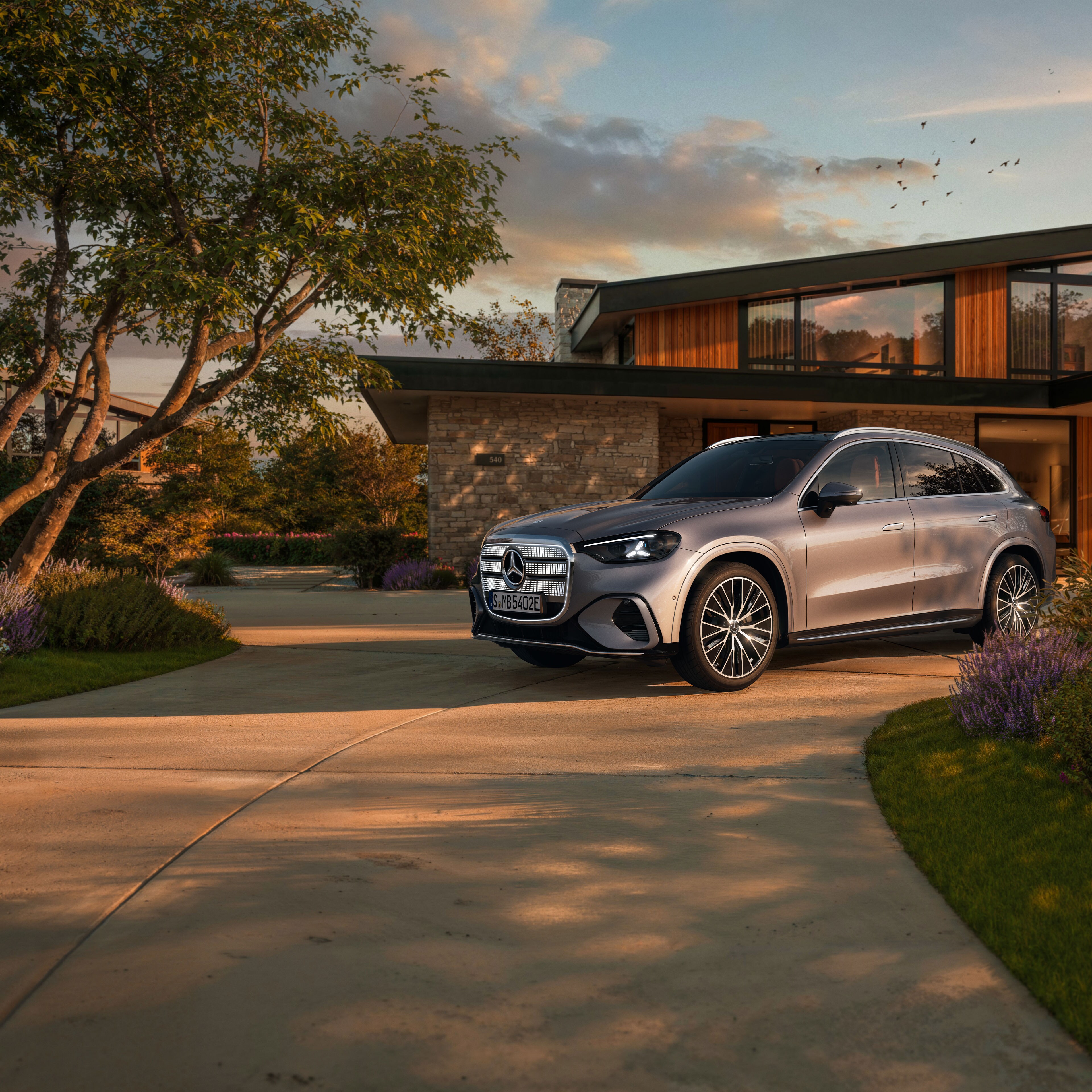 Nuevo GLC eléctrico | Mercedes-Benz El nuevo GLC eléctrico en gris aparcado fuera de una casa