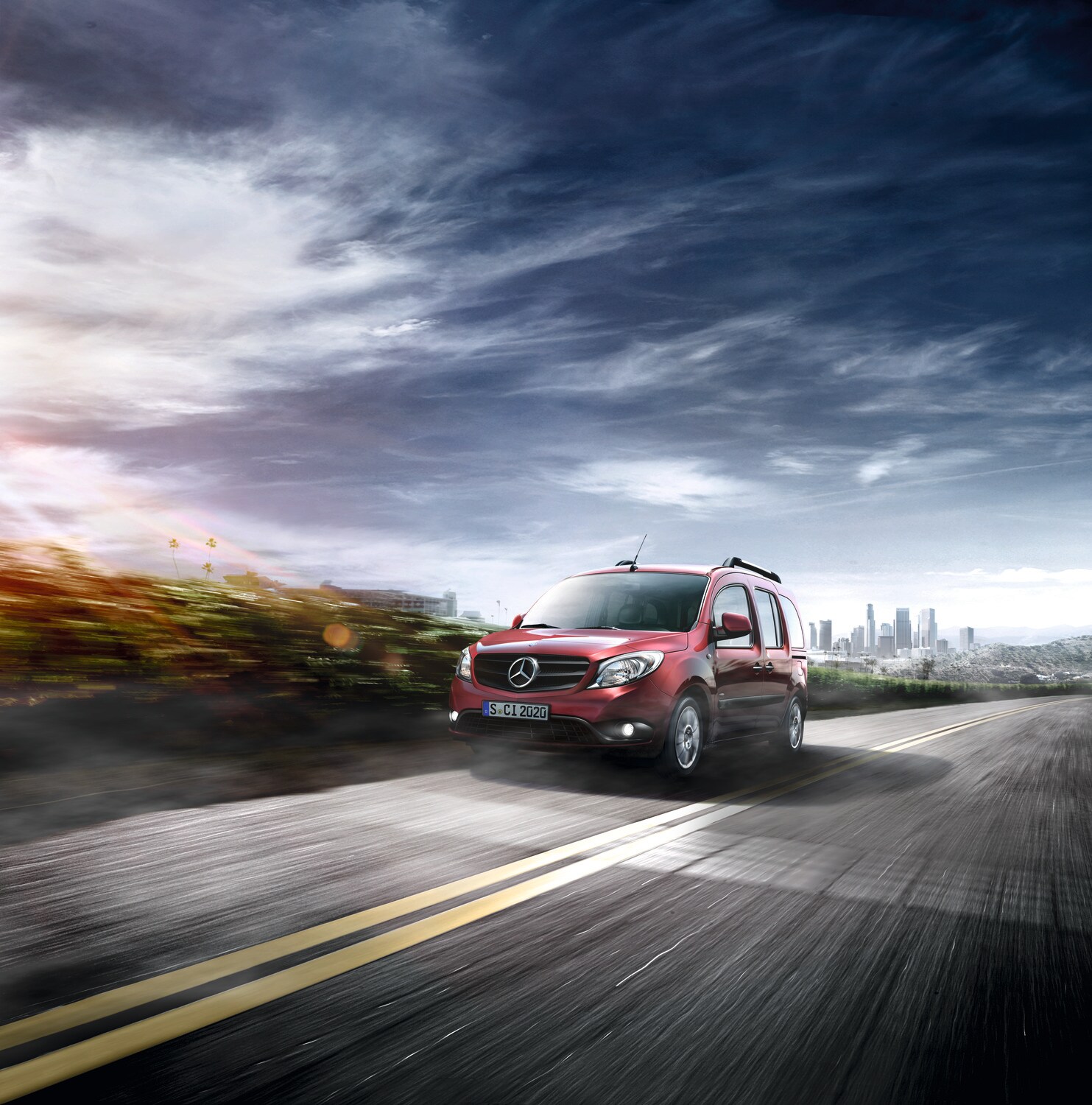 Explora el dinámico furgón Citan de Mercedes-Benz Mercedes-Benz Citan rojo transitando por una carretera con vistas panorámicas con el horizonte de la ciudad de fondo