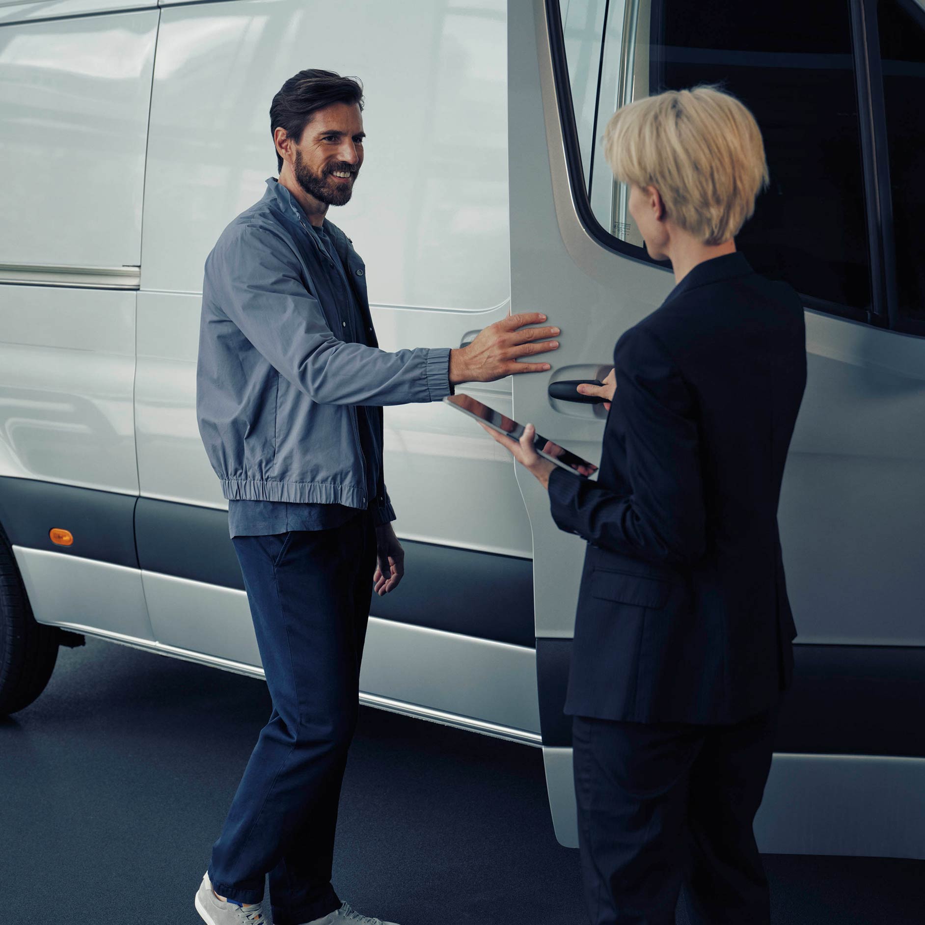 Vehículos nuevos | Financiación y precios | Servicios financieros | Mercedes-Benz Un hombre habla con un vendedor de Mercedes-Benz sobre una furgoneta eSprinter blanca