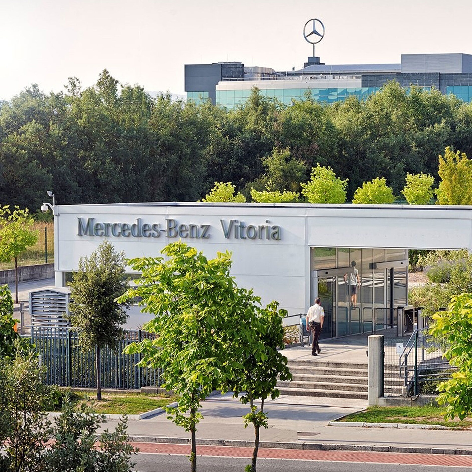 Fábrica Vitoria | Mercedes-Benz visual de la fábrica de Vitoria por fuera en color blanco y rodeada de árboles verdes