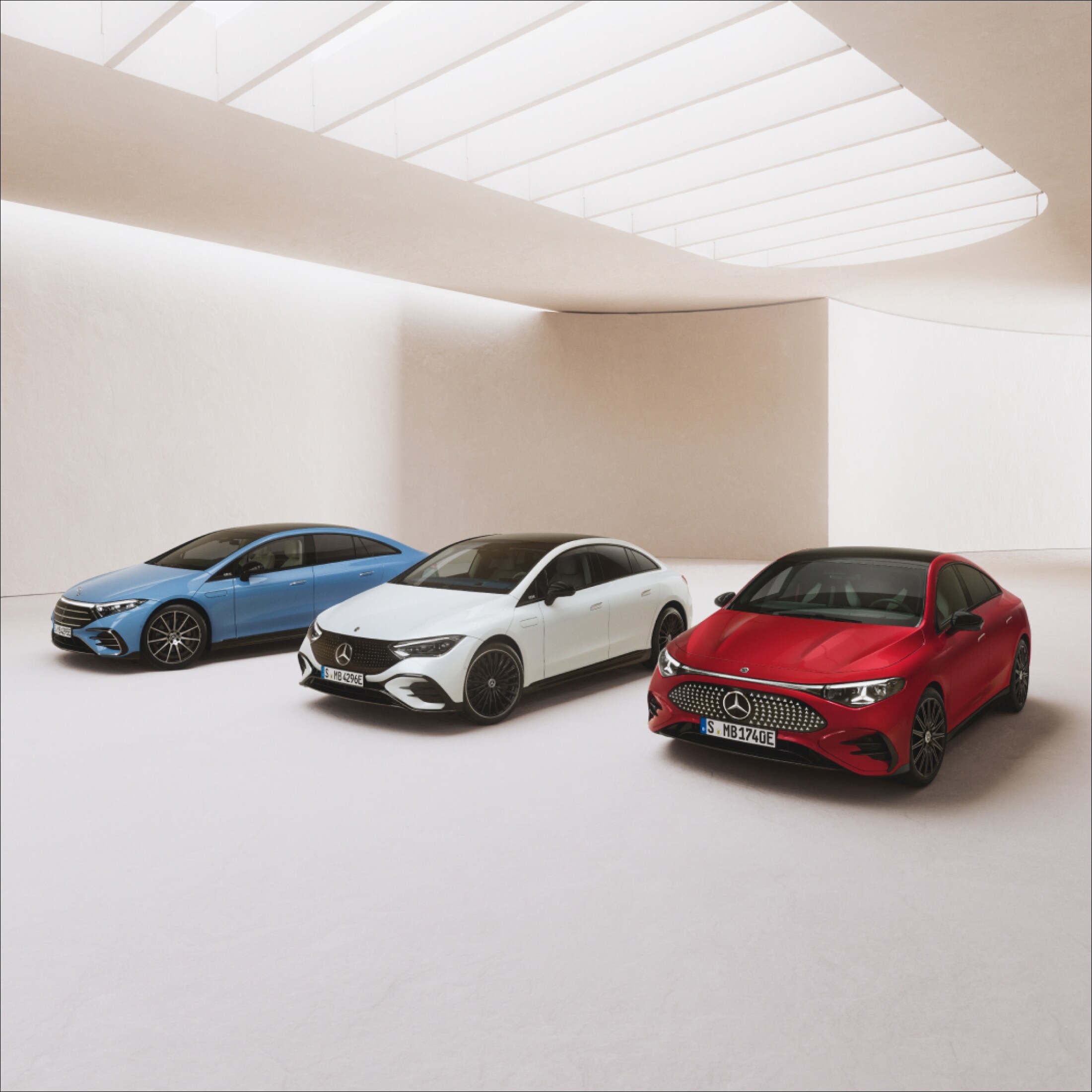 Visual de un Clase A blanco y un CLA rojo de Mercedes-Benz con una cortina roja volando sobre ellos